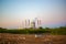 A thermal power plant produces emissions. Trash in the foreground.