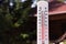 Thermometer on the background of a country house. An air temperature of 40 degrees is shown by a thermometer. Summer heat