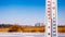 The thermometer on the background of spring landscape shows 3 degrees of heat. Early spring. Measurement of air temperature in