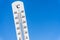 Thermometer in the blue sunny sky. Heatwave in summer.