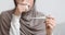 Thermometer in hands of unrecognizable sick muslim woman in hijab