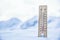 Thermometer on the mountains in the snow shows temperatures below zero. Low temperatures in degrees Celsius and fahrenheit
