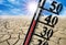 thermometer shows high temperature in summer heat with dryness and lack of water in field.