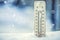 Thermometer on snow shows low temperatures under zero. Low temperatures in degrees Celsius and fahrenheit.