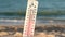 Thermometer for the temperature on the beach, in the summer in the heat. Global warming.