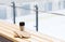 Thermos cup and mittens on bench at ice rink arena