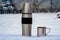 Thermos and cup in the winter outdoors. Hiking