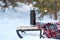 Thermos and warm woollen blanket on sled in snowy forest. Picnic in winter in forest