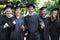 Theyre proud graduates. A group of happy students punching the air in celebration on graduation day.