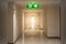 Theâ€‹ green emergency exit sign in hotel showing the way to escape