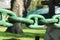 Thick antique chain painted in green light in a park