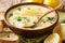 Thick aromatic Greek lemon soup with chicken and orzo paste close-up in a bowl. horizontal