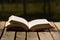 Thick book lying open on wooden surface, beautiful night light setting, magic concept shoot