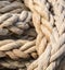 Thick braided rope is tied with a skein. Fishing rope background.