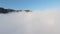 Thick clouds near high mountains. Shot. Beautiful clearing of clouds on background of mountain peaks and blue sky. Sunny