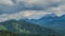 Thick clouds wreathing over mountains covered with green trees, amazing nature