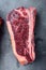 Thick fatty marbled raw beef club steak, on gray stone background, top view flat lay