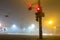 Thick fog over empty road with traffic lights at night