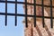 Thick metal grate covering the entrance to the fortress against the blue sky