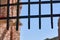 Thick metal grate covering the entrance to the fortress against the blue sky