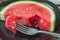 Thick slice of ripe watermelon with a small piece on a fork