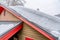 Thick snow accumulated on the pitched gray metal roof of house in winter