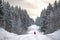 Thick snowy forest and man in red jacket