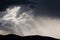 Thick stormy clouds over the mountains with intense sun rays peaking through and contrasty light