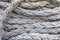 Thick twisted gray ship`s mooring rope close up