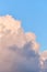 Thick vanilla clouds on a blue background with copy space. Vertical