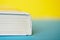 A thick white book or diary on a yellow and blue background. College or school science library. Close-up