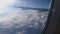 Thick white clouds glowing in bright sunshine below airplane carrying people