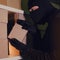 A thief in a black hood steals a parcel in a warehouse in the dark. Concept of problems with theft of goods and postal parcels