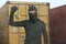 Thief at work - criminal man in black covered with balaclava mask holding unlocked padlock at shipping area break in storage