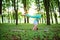 Thin brunette girl plays sports and performs yoga poses in a summer park on a sunset background. Woman doing exercises on the yoga