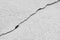 Thin crack diagonally. Big winding ascending crack on an gray concrete wall. Copy space. Black and white vertical photo. Selective