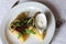 Thin crepes stuffed with spinach and mushrooms. With basil, arugula, violet flowers and sour cream. The dish is served on a table