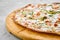 Thin-crust pizza dough with shrimps and slices of zucchini