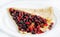 Thin delicious pancake with berries on white