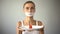 Thin girl with taped mouth holding plate with tomato, exhausting diet, anorexia