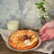 Thin pancakes with cherries. Pancakes in a white plate. Wood background. Plate with food in the hands