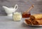 thin pancakes envelope filled with cottage cheese and raisins on a saucer with honey on a gray background