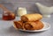 thin pancakes envelope filled with cottage cheese and raisins on a saucer with honey on a gray background