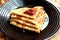 Thin pancakes stacked on a plate and poured with jam