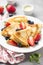 Thin pancakes with strawberries and blueberries, jam, condensed milk, delicious Breakfast. Russian traditional dessert for