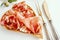 thin slices of jamon are laid out on a wooden board made of olive wood. Close-up of a thin slice of Iberian ham ham on a