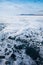 Thin snow forms whimsical patterns on the ice  Baikal and mountains in the distance with the sky