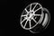 Thin-spoke cast disc, sports wheel on a black background, minimalism.