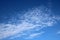 Thin white fluffly clouds in blue sky on sunny day