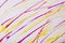 Thin yellow and purple lines and splashes drawn on white background. Abstract art backdrop with brush decorative stroke